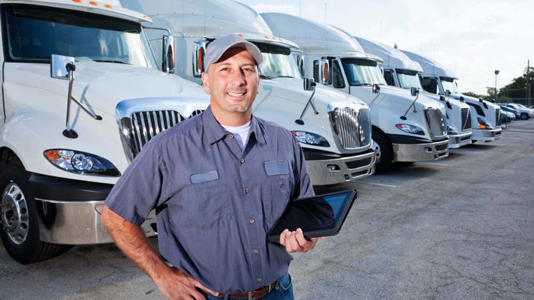 A man standing in front of trucks.